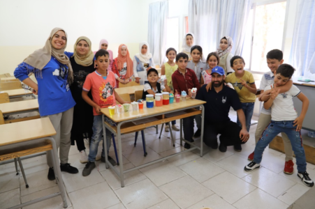 Houda con niños huérfanos sirios en clase de ciencias haciendo experimentos