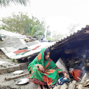 Mujer sentada en medio de los escombros causados por el ciclón Bulbul en Bangladesh