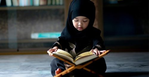 Niña leyendo el Corán