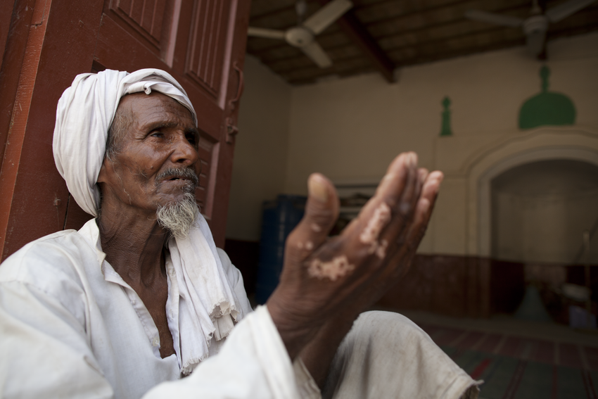 Hombre pakistaní alzando sus manos en una plegaria