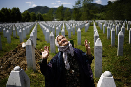 La mujer reacciona mientras se para cerca de la tumba de un pariente en el Memorial de la masacre de Srebrenica