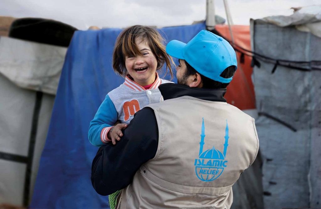 Mariam con un trabajador de Islamic Relief en brazos