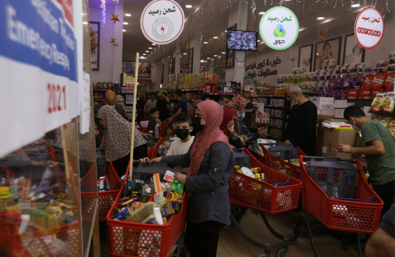 Familias comprando en un supermercado en Gaza utilizando vales de alimentos
