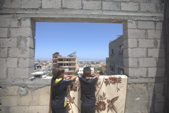 Dos niños de Gaza mirando por la ventana