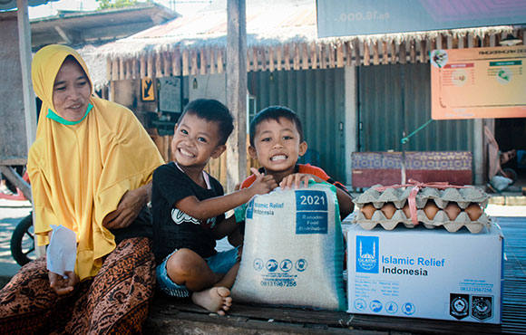 Una familia recibiendo paquetes de alimentos