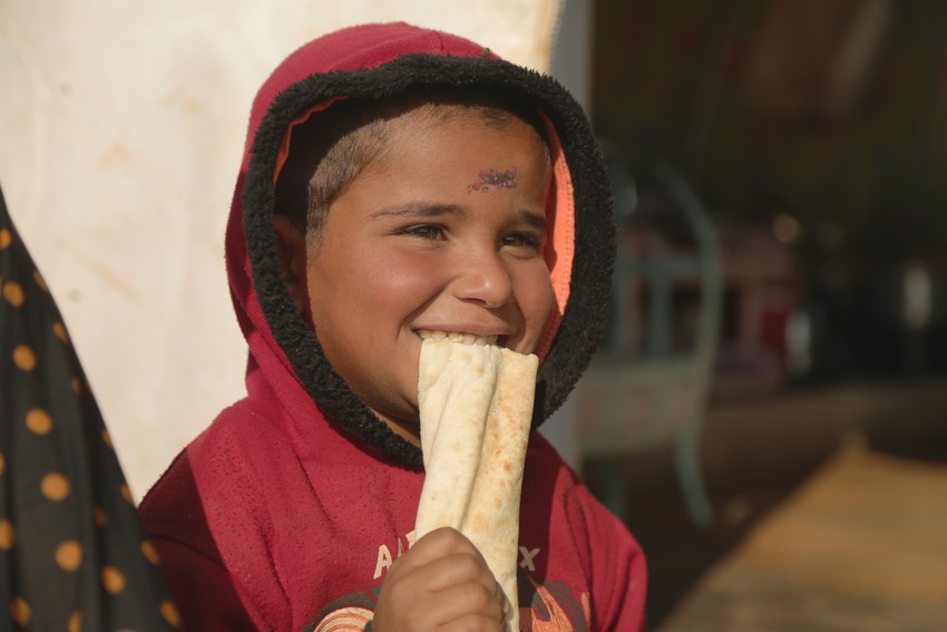 Niño sirio comiendo pan