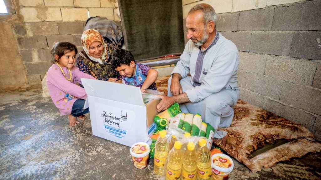 Familia recibiendo un paquete de alimentos en Ramadán