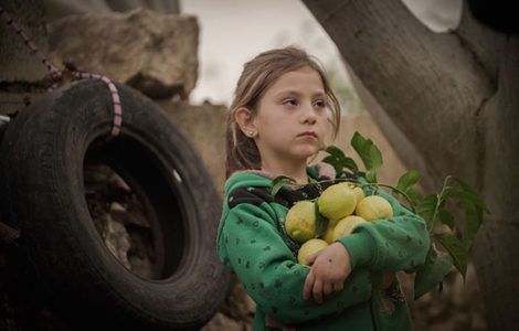 Niña siria sujetando unos limones