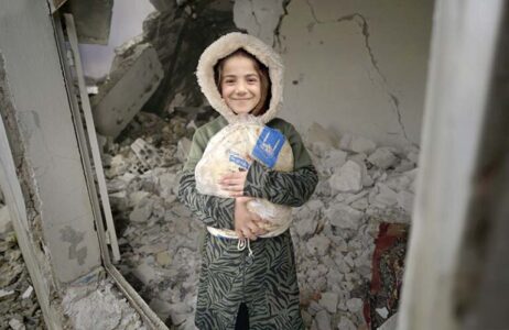 Niña siria sosteniendo pan árabe
