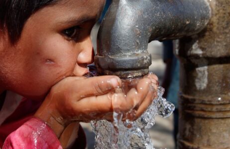 Niña bebiendo agua de una fuente