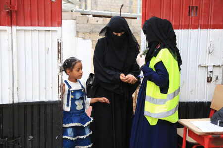 Al llegar a un punto de distribución de Islamic Relief para recoger la carne de udhiya de su familia, Hana y su hija se desinfectan las manos como parte de nuestras medidas para prevenir la propagación del Covid-19.