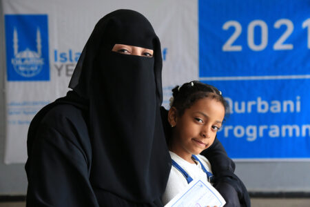 Hana y sus hija recibiendo carne de Udhiya de Islamic Relief