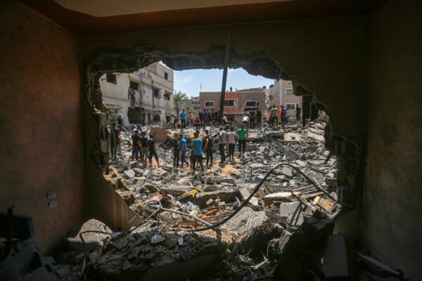 Los residentes se paran en medio de los escombros de un edificio en Gaza.